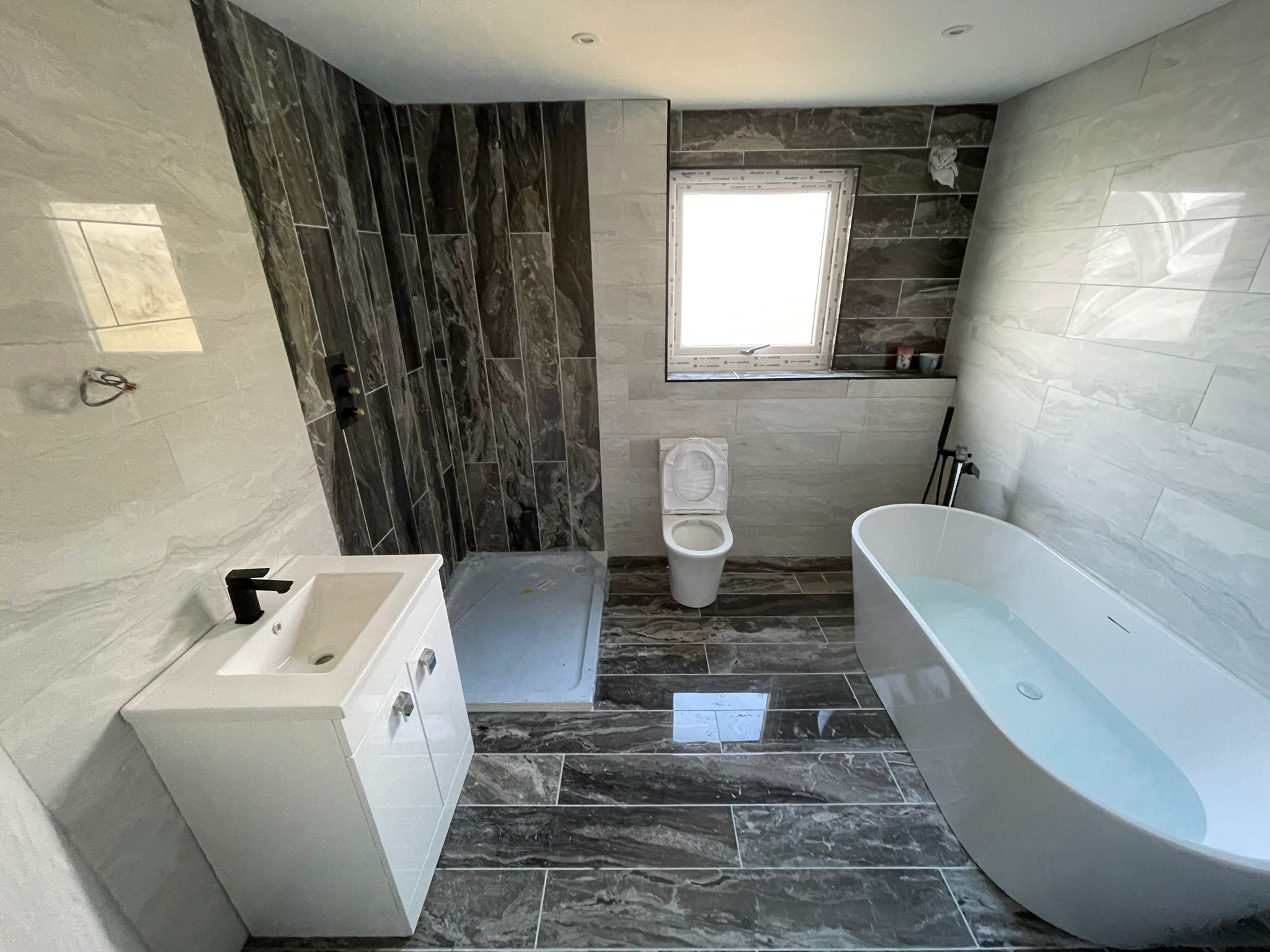 Bathroom mid-install with freestanding bath