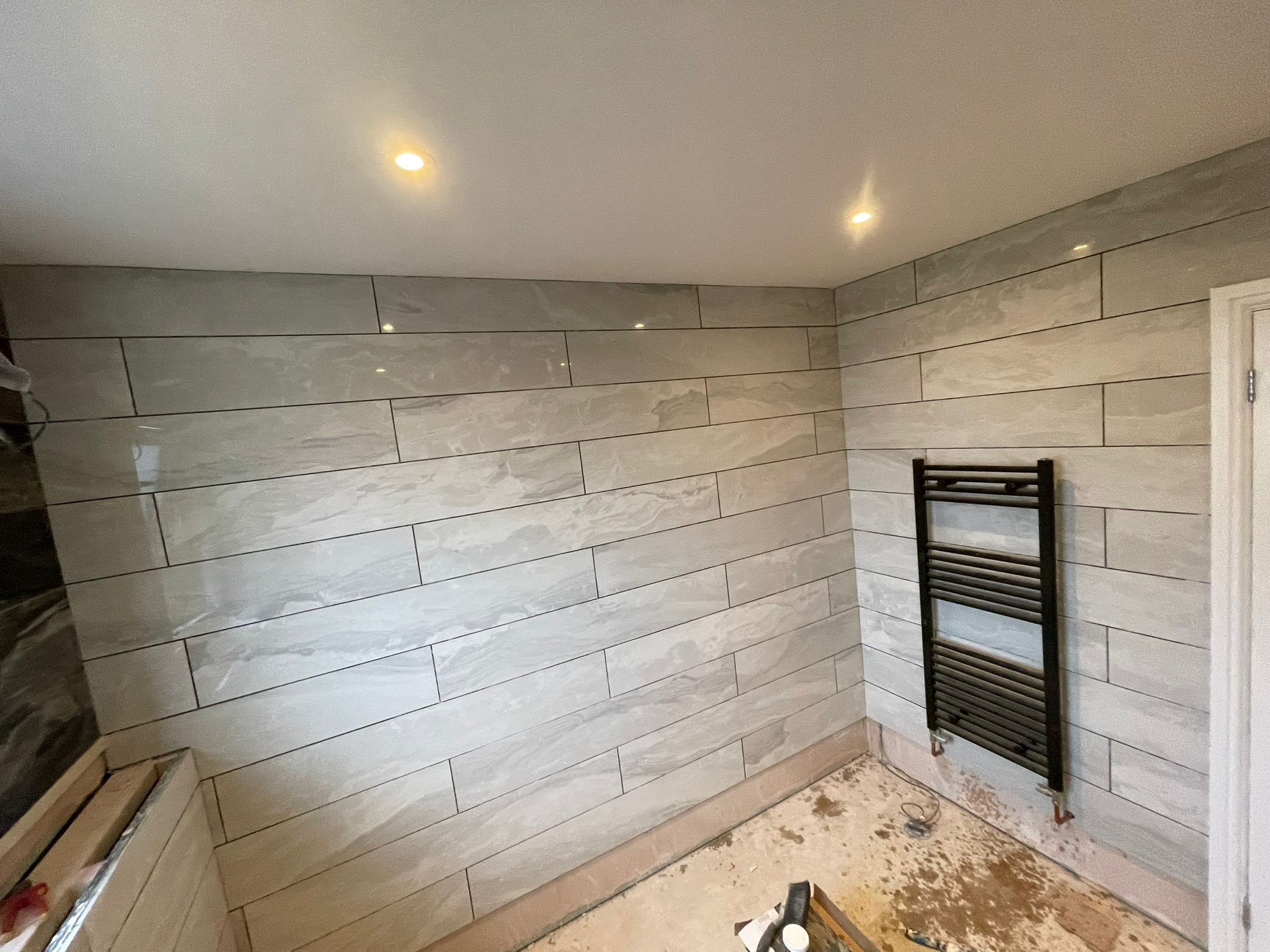 Bathroom wall tiling with towel radiator