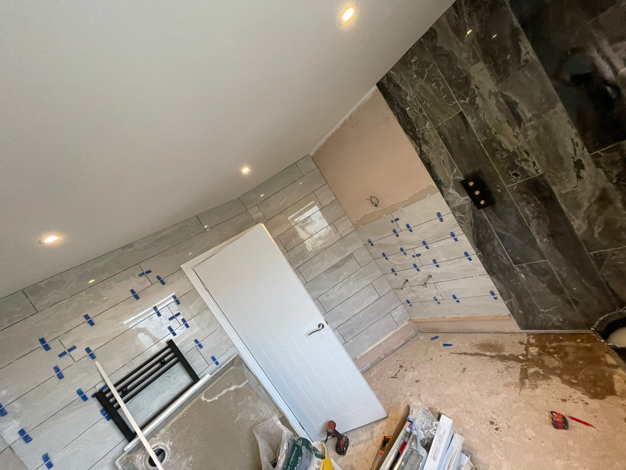 Bathroom tiling early stage with dark marble feature
